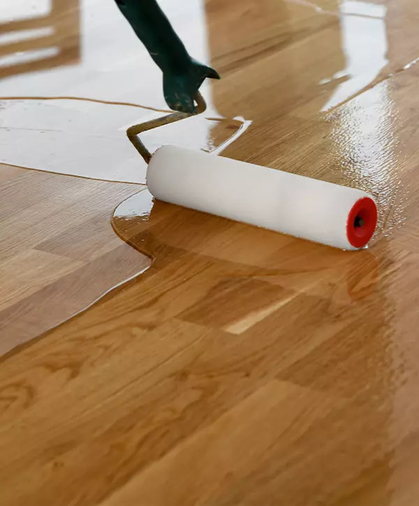 Hardwood-Floor-Recoating-In-Modesto-Lacquering-wood-floors_-Worker-uses-a-roller-to-coating-floors.webp